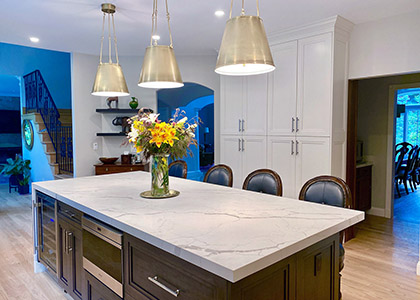 Katonah, NY - UltraCraft kitchen cabinets painted in Melted Brie with cherry island stained Platinum and Quartz Countertop by Cambria